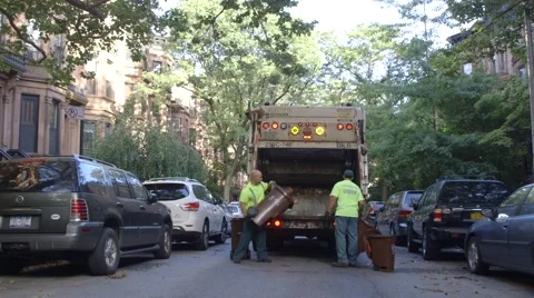 Sanitation workers collecting garbage in garbage truck Stock Footage