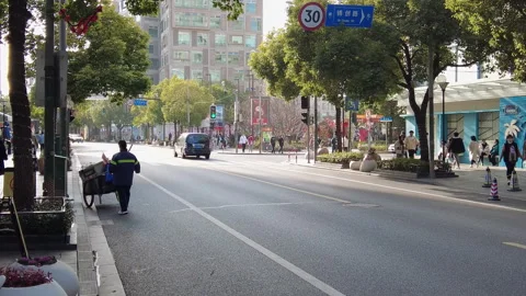 Sanitation workers pushing their carts along Shanghai University Road Stock Footage 253457382