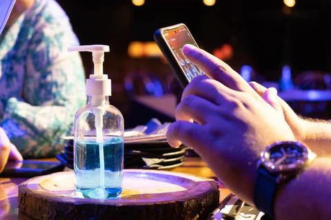 Sanitizer bottle with QR code for digital menu being scanned on mobile phone  Foto stock