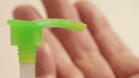 Sanitizer dispenser liquid flow in sharp focus, hand soft focus 動画素材 127390671
