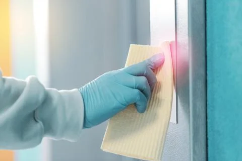 Sanitizing an elevator push button against bacteria and virus. Foto stock