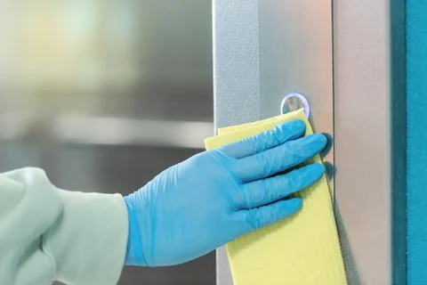 Sanitizing an elevator push button against bacteria and virus. Foto stock