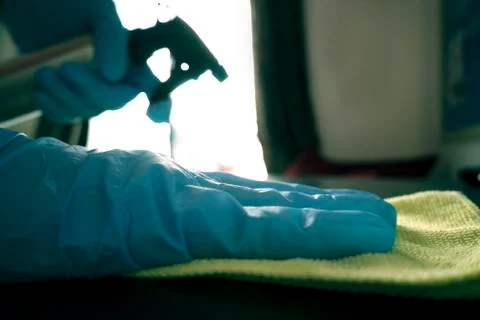 Sanitizing a table with gloves on due to COVID-19 outbreak Stock Photos