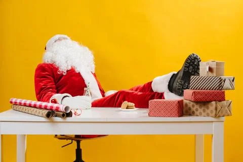 Santa Claus also needs an ocasional break. He's working at the desk. Stock Photos
