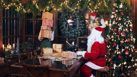 Santa claus and elves stack new year's gift boxes. Stock Footage 118859987