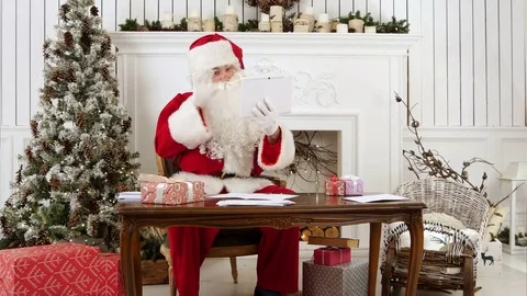 Santa Claus cheerfully talking via tablet Stock Footage 70947939