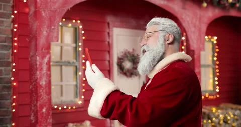 Santa Claus communicates via video link with someone using smartphone on the Stock Footage 164911084