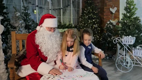 Santa Claus Entertains Kids Eagerly Boy and Girl Playing Together Talking to Stock Footage 71634341