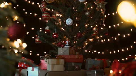 Santa claus figurine with stack of gift boxes under a decorated christmas tree Video stock 141710635
