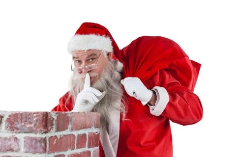 Santa claus with finger on lips standing beside chimney Stock Photos