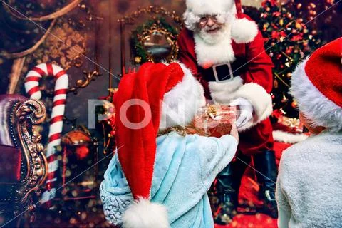 Santa Claus is giving presents to children at home. Merry Christmas and Happy Stock Photos