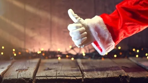 Santa Claus hand thumb up gesture over Christmas holiday wooden background Stock Footage 81069151