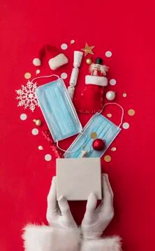 Santa Claus holding an exploding Christmas gift with protective masks Foto stock