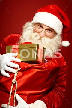 Santa Claus holding sack of gift boxes Stock Photos