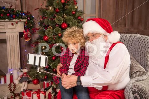 Santa Claus with kid taking selfie Stock Photos