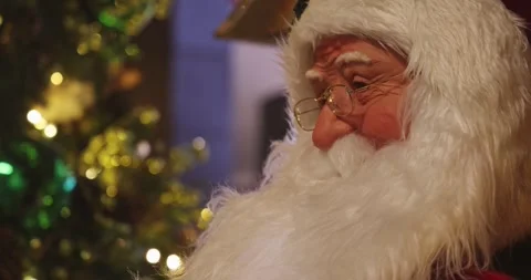 Santa Claus looking down, Christmas tree background, holiday decor Stockbeeldmateriaal 343557270