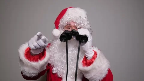 Santa claus looking through binoculars and pointing Stock Footage 323914487