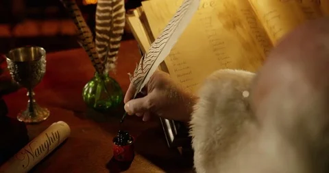 Santa Claus makes final adjustments to his list with a quill pen. Stock Footage 81847381