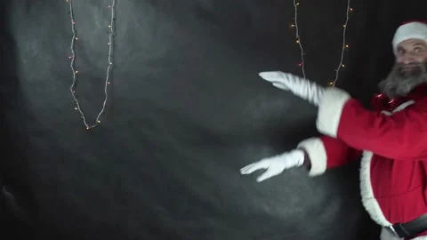 Santa claus makes waves and shows enough on dark gray background. Strange middle Stock Footage 221429509