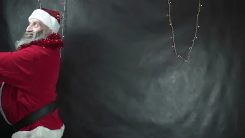 Santa claus makes waves on dark gray background. Strange middle-aged man with Stock Footage 221429468