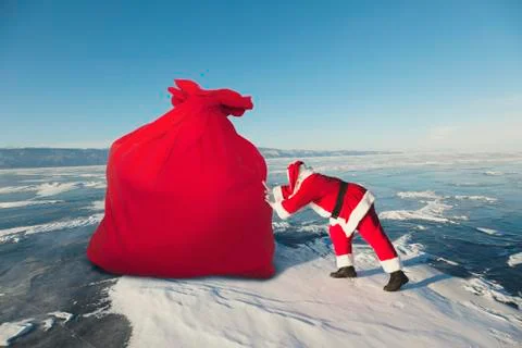 Santa Claus pulls big red bag outdoors Foto stock