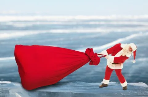 Santa Claus pulls big red bag outdoors Foto stock