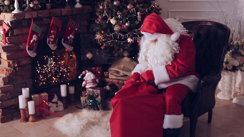 Santa Claus pulls a gift out the bag Stock-Footage 70085340