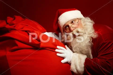 Santa Claus pushing a big sack Stock Photos