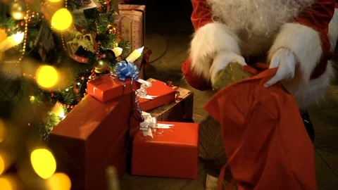 Santa Claus putting gifts under Christmas tree Stock Footage