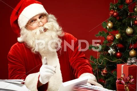 Santa Claus Reading Letters And Looking At Camera
