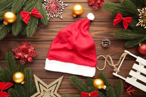 Santa Claus red hat and decoration on brown background. Christmas decoration. Stock Photos