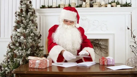 Santa Claus sorting out paper letters from children Stock Footage 70947715