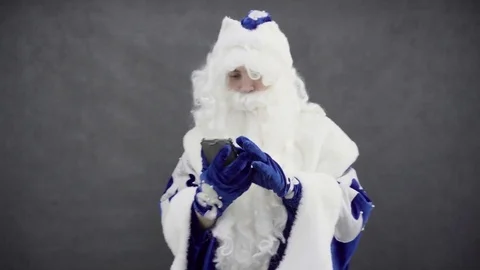 Santa claus is typing something on his smartphone Stock Footage 76324845