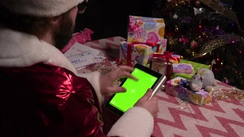Santa Claus is using the green screen of the tablet for shopping.Tablet with a Stockbeeldmateriaal 162563983