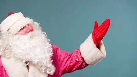 Santa Claus waves gloved hand greeting everyone one hand look in distance right Stock Footage 211681495