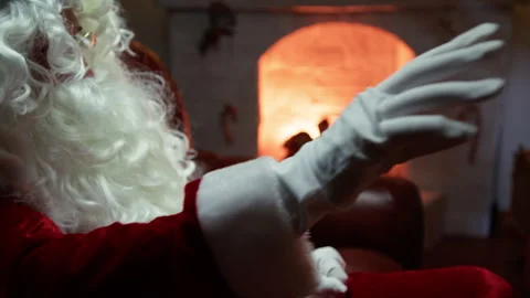 Santa Claus waves his hands in front of the fireplace Stock Footage 291990571