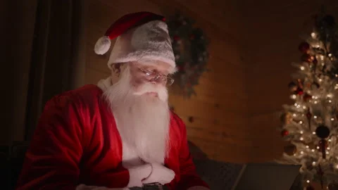 Santa Claus is working on a computer at home with glasses and a beard magical Stock Footage 166158644