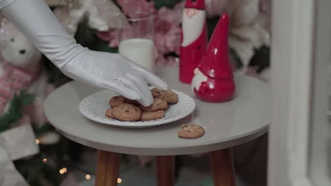 Santa Claus's gloved hand picking up a cookie Stock Footage 340084991
