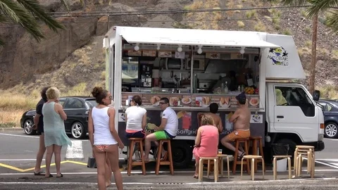 Santa Cruz Tenerife Spain: People eating at a food truck next to the beach Stock Footage