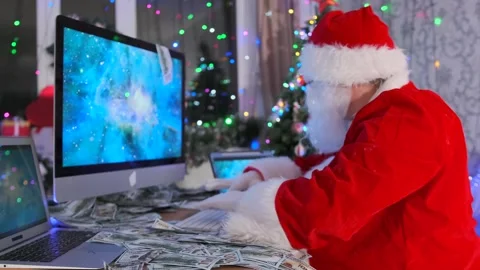 Santa distributes Christmas gift orders in front of monitors at a desk Vídeo Stock 288281007