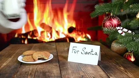 Santa eats oatmeal cookies, drinks a glass of milk and leaves a gift on the Stock-Footage 220131153