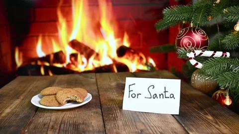 Santa eats oatmeal cookies, drinks a glass of milk and leaves a gift on the Stock-Footage 221413351