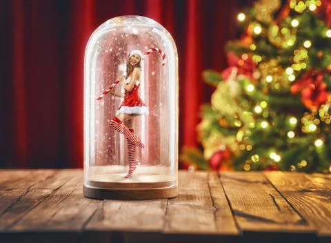 Santa girl inside a Christmas snow globe. Stock Photos