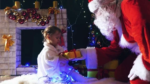 Santa gives a gift box to cute little girl, Christmas Stock Footage 70126157