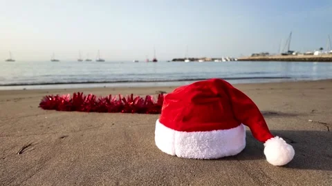 Santa hat resting on a tropical sandy beach Stock Footage 346249300