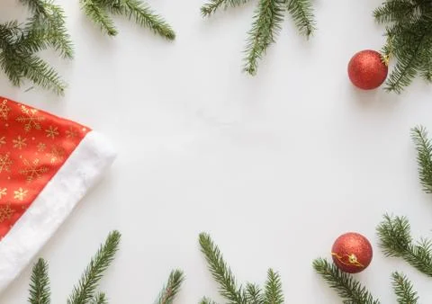 Santa hat, two red balls and christmas tree branches. Stock Photos