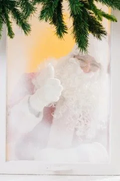Santa is looking at us through the window and thumbs up. Merry Christmas. Stock Photos