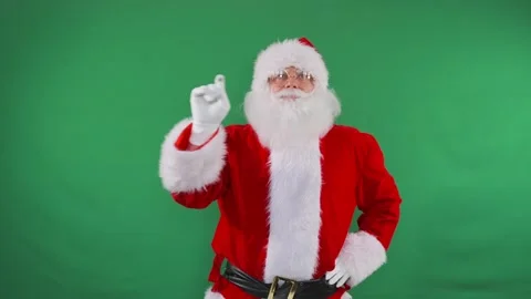 Santa presses buttons on a green screen, creating dynamic holiday scenes. Stock Footage 292537126