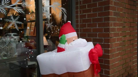 Santa rises from a stocking in a Christmas display, 4k Stock Footage 223927060