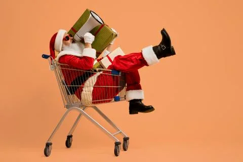 Santa shouting in megaphone while sitting in shopping cart Stock Photos